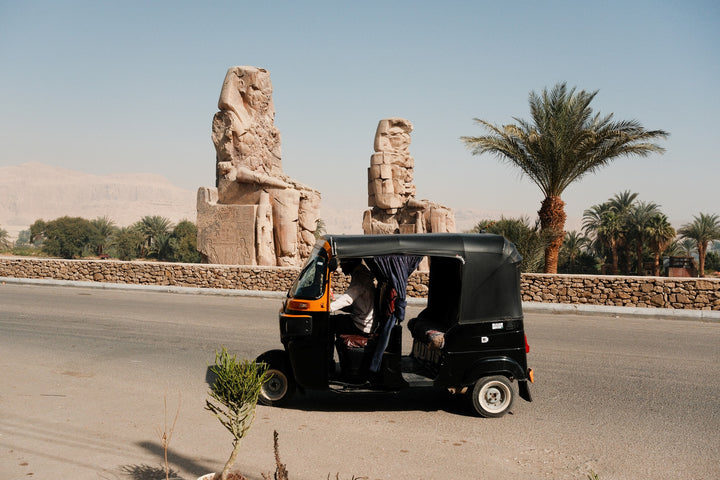 Toktok at the Colossi of Memnon in Luxor framed in black wood, 30×40 cm frame