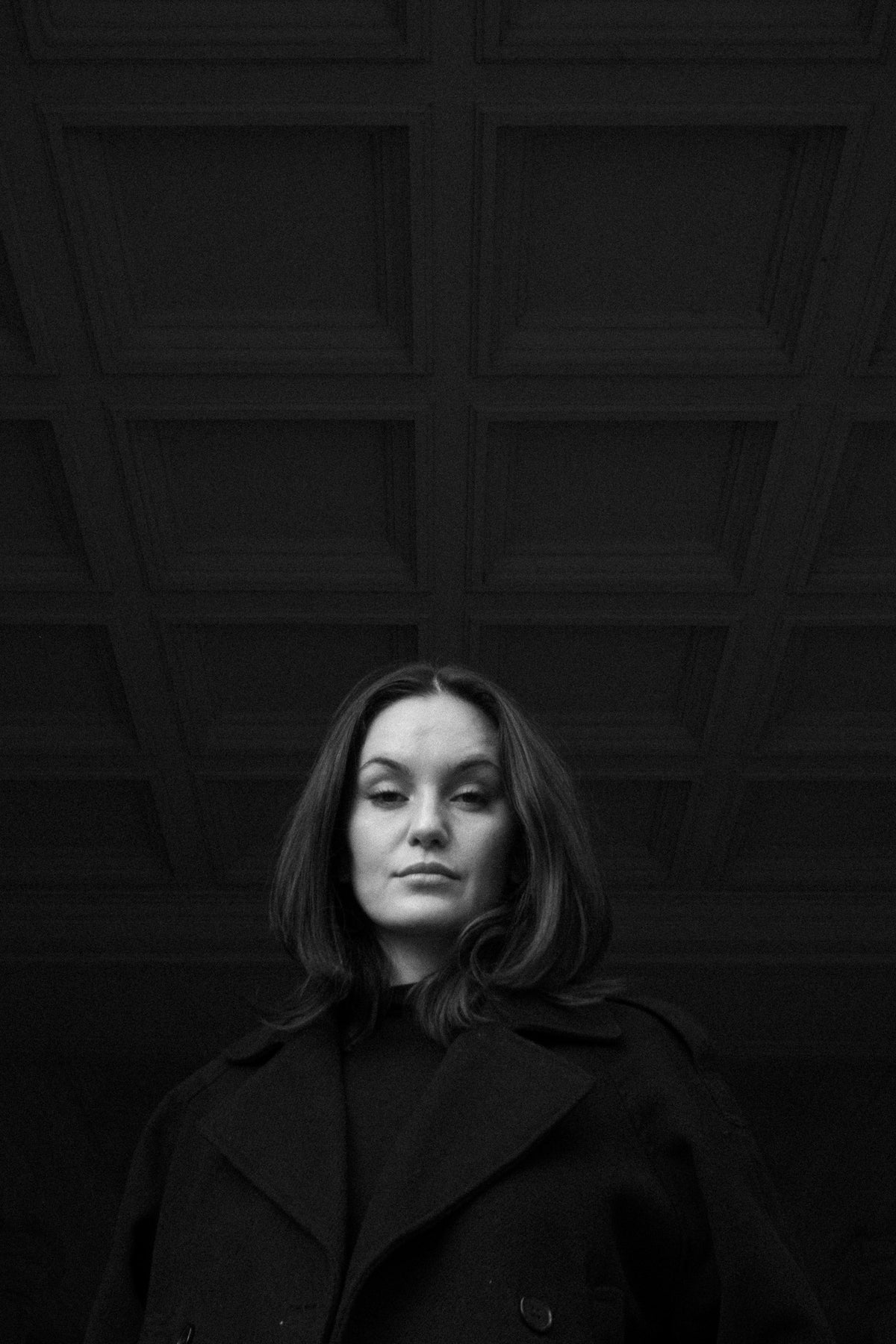 Helena Wedekind under a coffered ceiling, looking straight into the camera