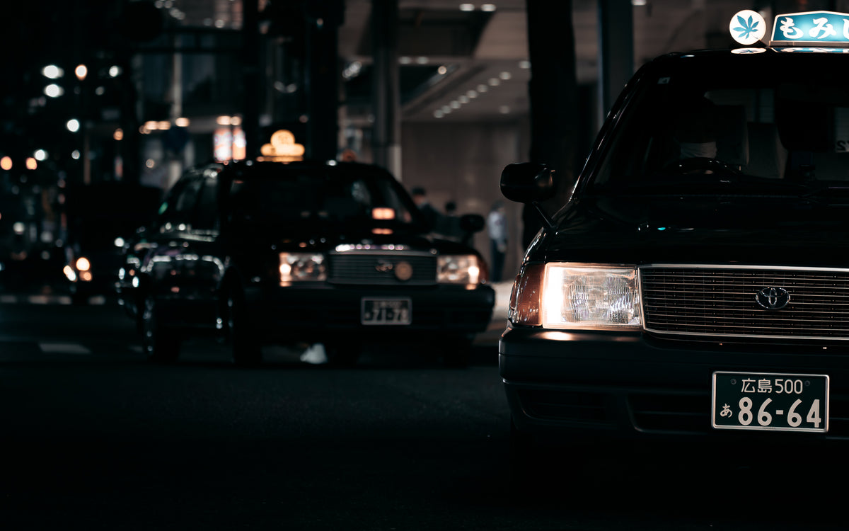 Two taxis at a junction at night